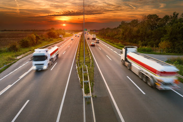 Fototapeta na wymiar Two white trucks in motion blur on the highway