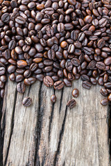 Background above a pile of coffee beans scattered on old wood