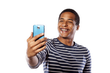 Smiling dark-skinned young man making selfie on white background