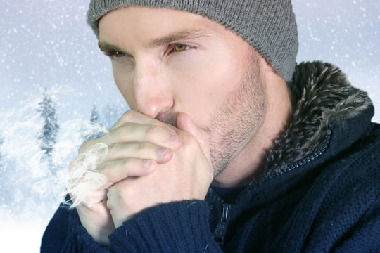 homme soufflant dans ses mains &agrave; cause du froid