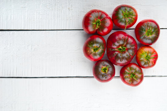Tomatoes with drops on wooden background