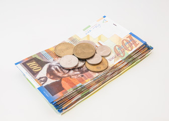 stack of israeli shekel notes with coins