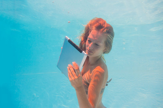 Young woman undewater with tablet computer