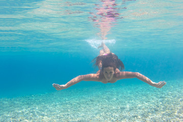 Young woman swimming undewater in the sea