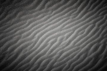 Wavy beach sand texture. Black and white with vignette.