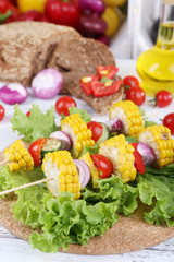 Sliced vegetables on picks on board on table close-up