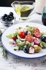 Plate of Greek salad served with wine and olive oil