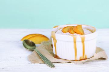 Tasty mini cake with fresh peach, on wooden table