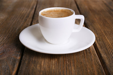 Cup of coffee with milk on wooden background
