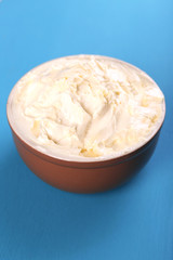 Fresh homemade butter in bowl, on color wooden background