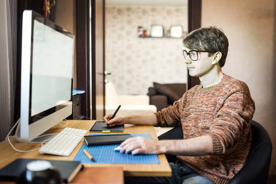 Young man at home using a computer, freelance developer or desig