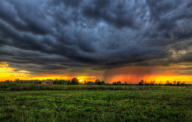 Дождевая туча на закате в поле