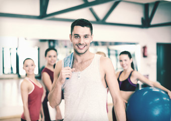 smiling man standing in front of the group in gym