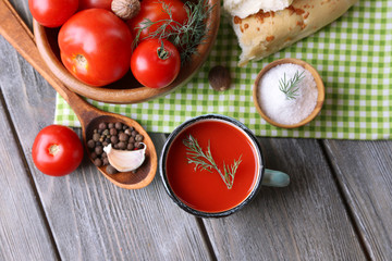 Homemade tomato juice in color mug, bread sticks, spices and