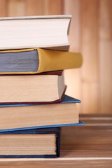 Books on wooden table on wooden wall background