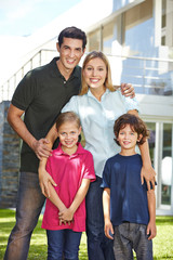 Portrait einer Familie vor Haus