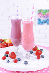 Delicious berry cocktails on table on brick wall background