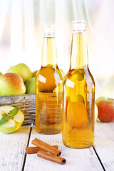 still life with apple cider and fresh apples on wooden table