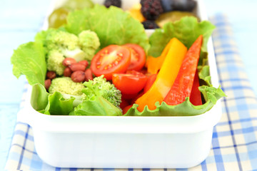 Tasty vegetarian food in plastic box on wooden table