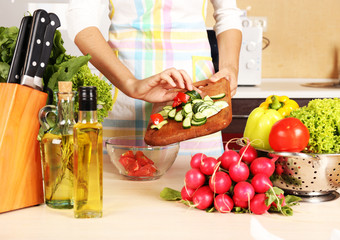 Woman cooking vegetable salad in kitchen
