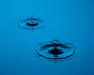 Two water drops on a calm surface