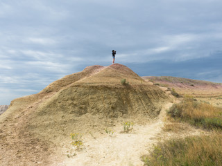 A tourist on the top of sandy hill in Badlands, South Dakota