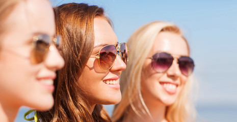 close up of smiling young women in sunglasses