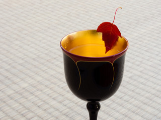 Red maple leaf in a golden cup