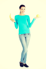 Young happy beautiful woman holding fresh fruits.