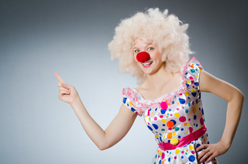 Clown with white wig against grey background
