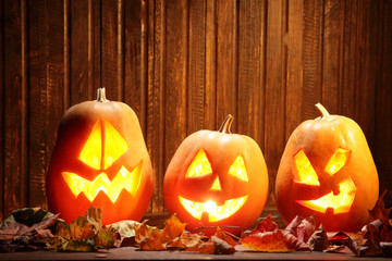 Jack o lanterns  Halloween pumpkin face on wooden background and