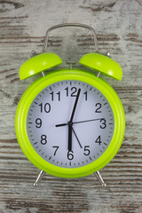 Green alarm clock with vintage background