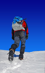 trekker with a backpack on snow