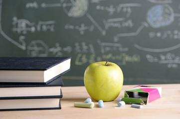 Apple on pile of books and pencils