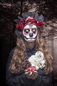A woman in Halloween costume and skull makeup