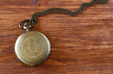 macro image of old vintage pocket watch on wooden table. top vie