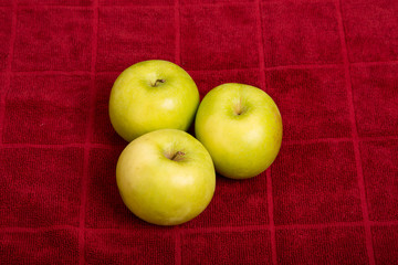Three Granny Smith Apples on Red Towel