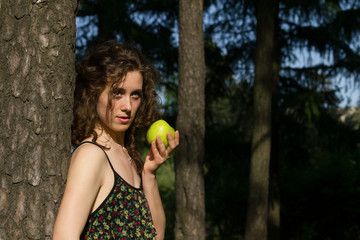 beautiful young woman eating apple outdoors