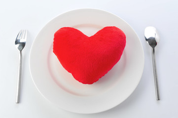 Red heart in plate with fork and spoon