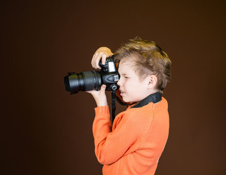 Child in studio with professional camera. Boy using camera.