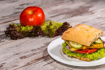 Close-up picture of vegetarian sandwich with tofu, tomatoes, sal
