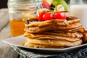 Pancakes with chocolate sauce fruit and glass of milk