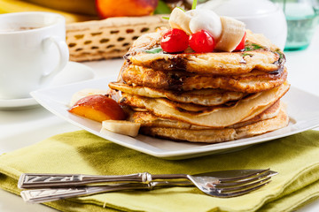 Pancakes with chocolate sauce fruit and coffee