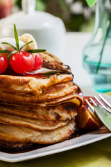 Pancakes with chocolate sauce fruit and coffee