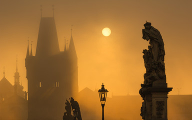 Silhouette of statue on Charles bridge during sunrise