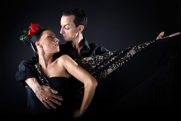 Young flamenco dancers in beautiful dress on black background. - obrazy, fototapety, plakaty