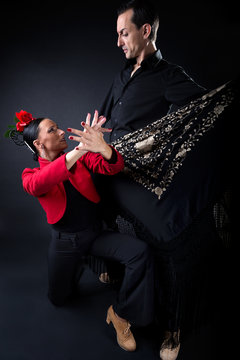 Young flamenco dancers in beautiful dress on black background.