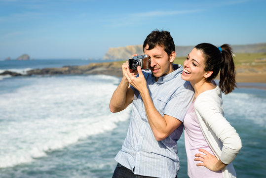 Young couple taking photo to the sea