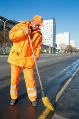 Road sweeper cleaning city street with broom tool