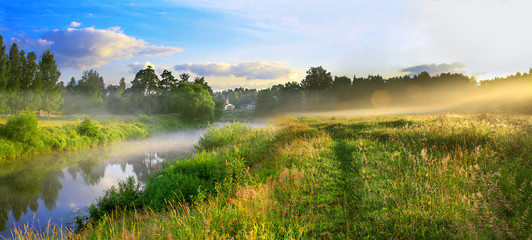 panorama van een zomerlandschap met zonsopgang, mist en de rivier